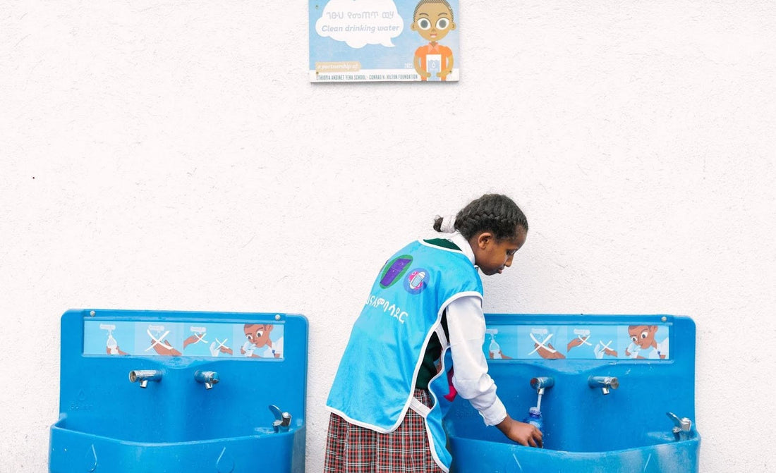 Child filling water bottle at school